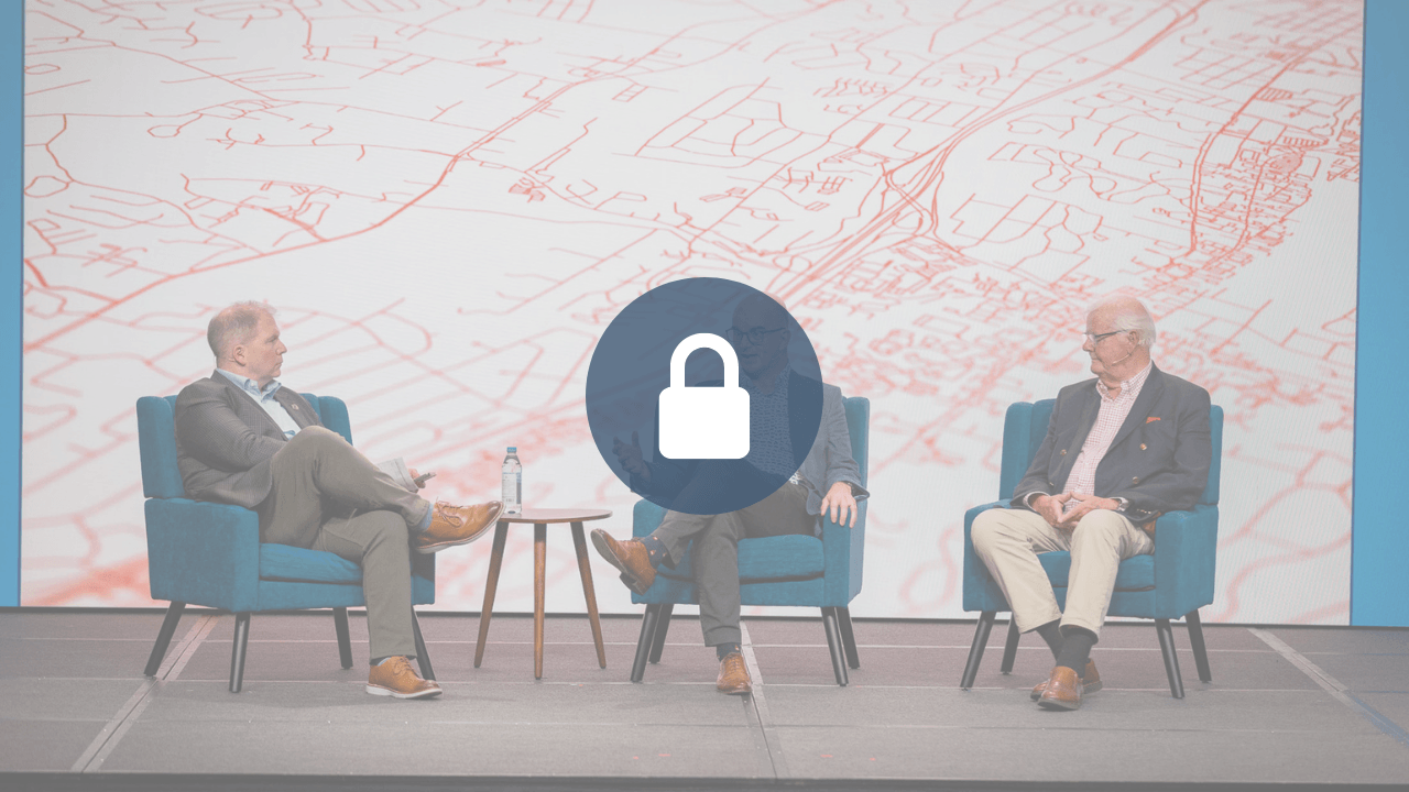 Locked session video: three men, Carl Trueman, Ph.D., Os Guinness, D.Phil, and John Stonestreet, seated in blue armchairs on a conference stage in panel discussion, with a stylized red street-map backdrop; a padlock icon overlays the center.